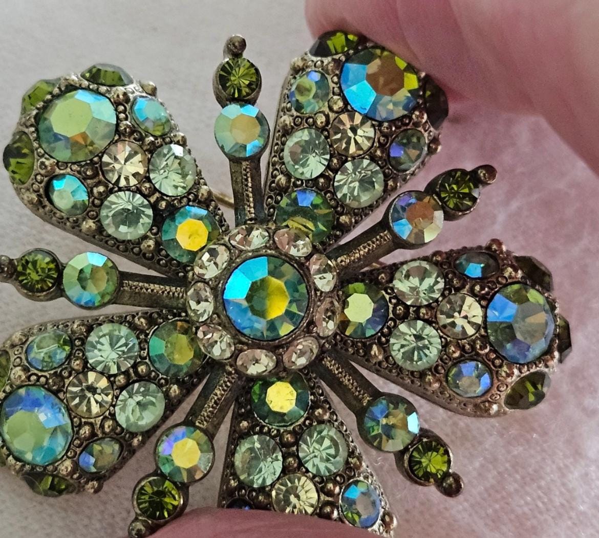 Joan Rivers Star Burst Brooch: Elegant Gold-Toned Accessory with Opalescent Green Crystals